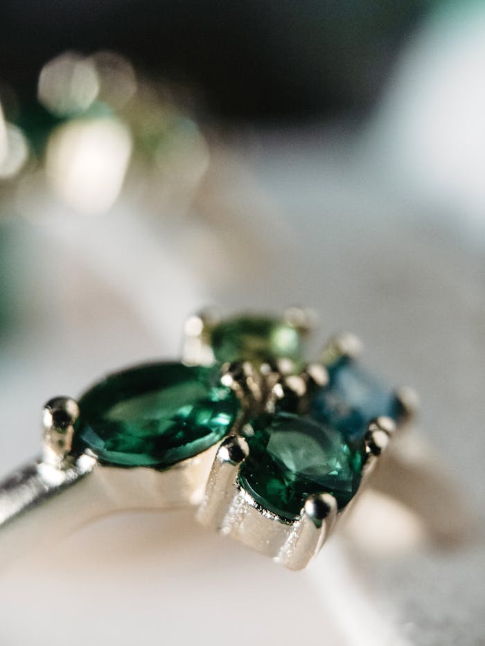 Detailed close-up of beautiful green and blue gemstone rings, showcasing stunning jewelry craftsmanship.